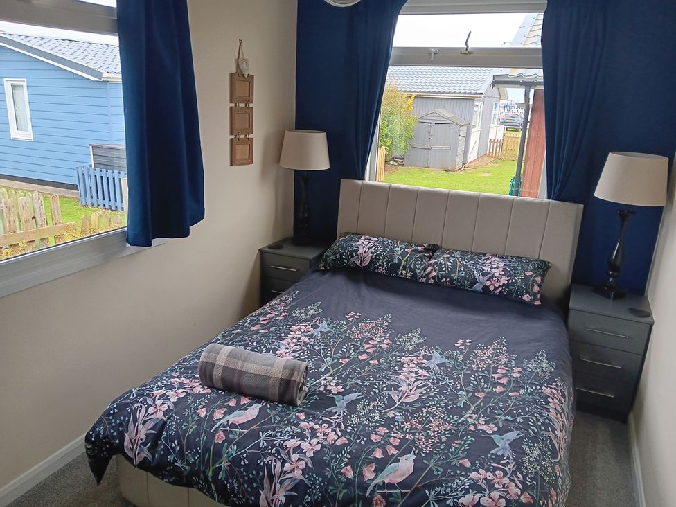 A bedroom with a bed and bedside tables at Seahorse Chalet Sleeps 6 Pets Log Burner Beach in Bridlington