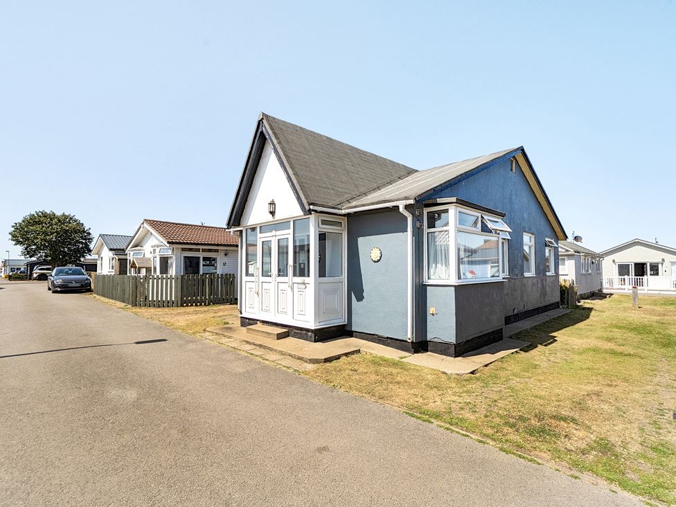 A house with a driveway and fence at Seahorse Chalet Sleeps 6 Pets Log Burner Beach Bridlington