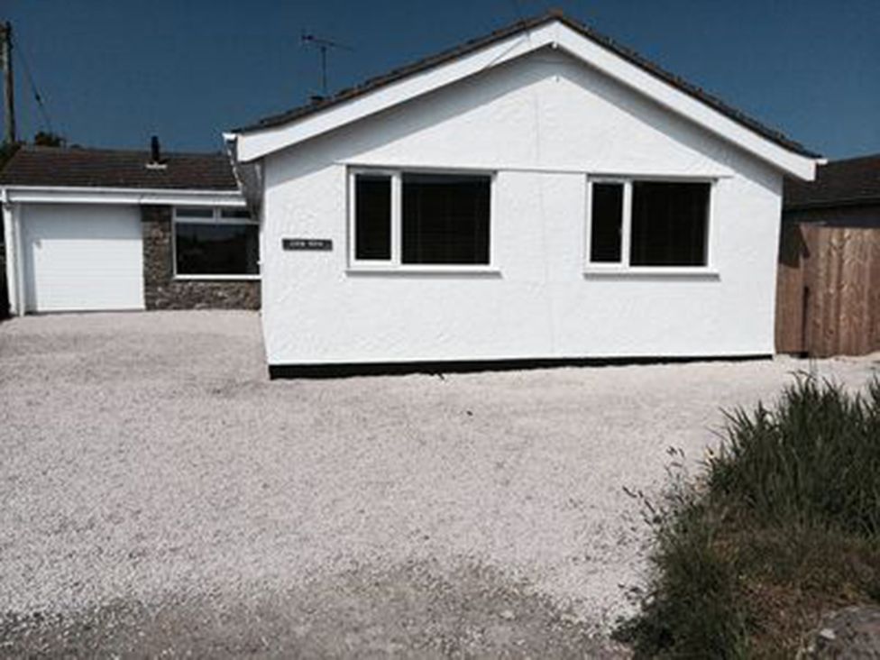 A house with a garage and driveway at Sea Side Stay 6 Pet Friendly Parking Garden Rhosneigr