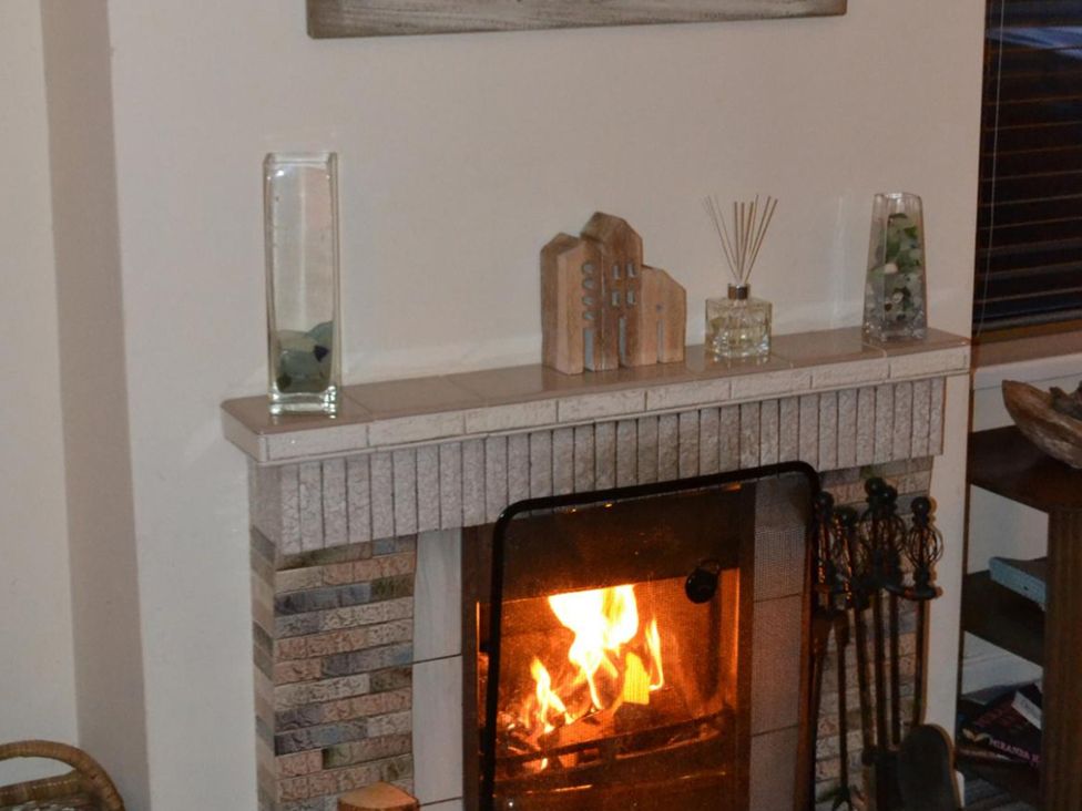 A fireplace with decorative items on the mantel at Sea Side Stay 6 Pet Friendly Parking Garden Rhosneigr