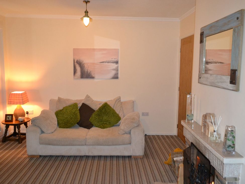A living room with a sofa and lamp at Sea Side Stay 6 Pet Friendly Parking Garden Rhosneigr