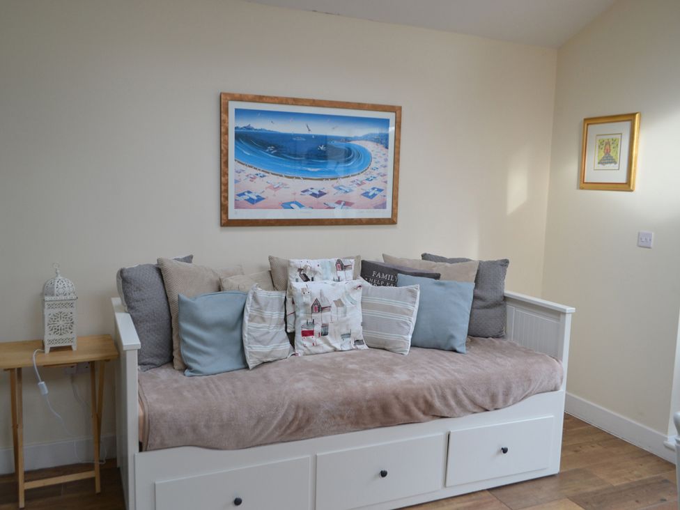 A sitting room with a sofa and decorative cushions at Sea Side Stay 6 Pet Friendly Parking Garden in Rhosneigr