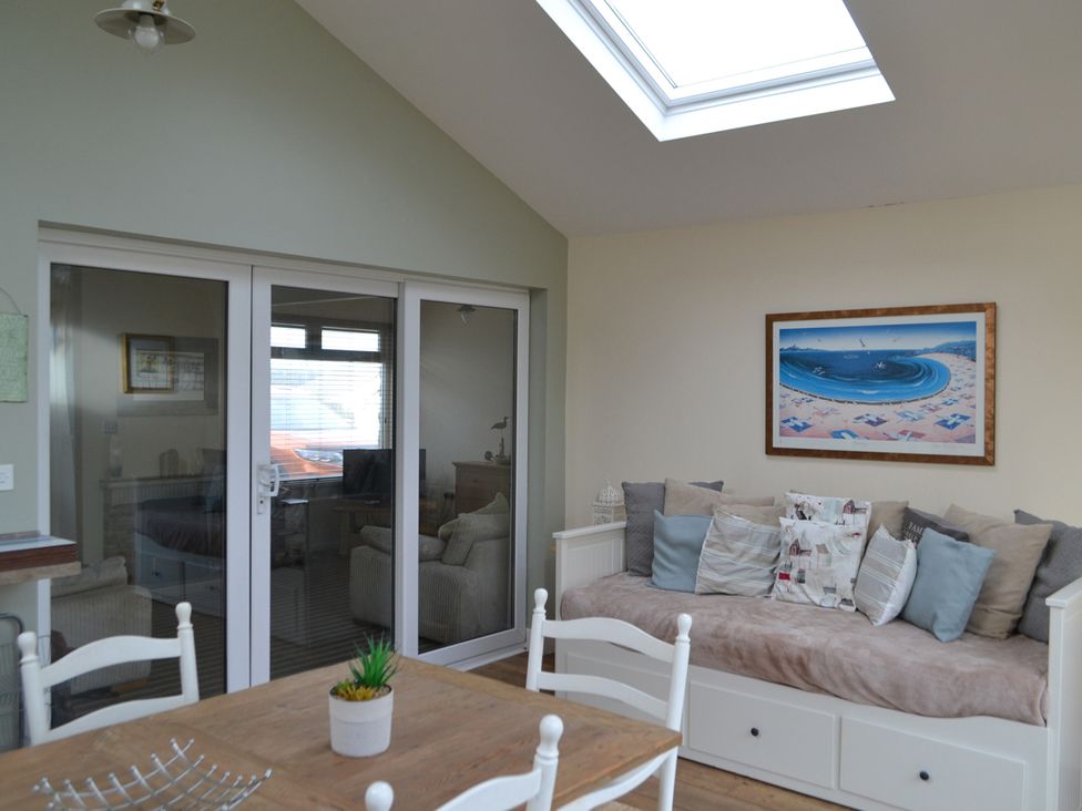 A living room with a sofa and table at Sea Side Stay 6 Pet Friendly Parking Garden Rhosneigr