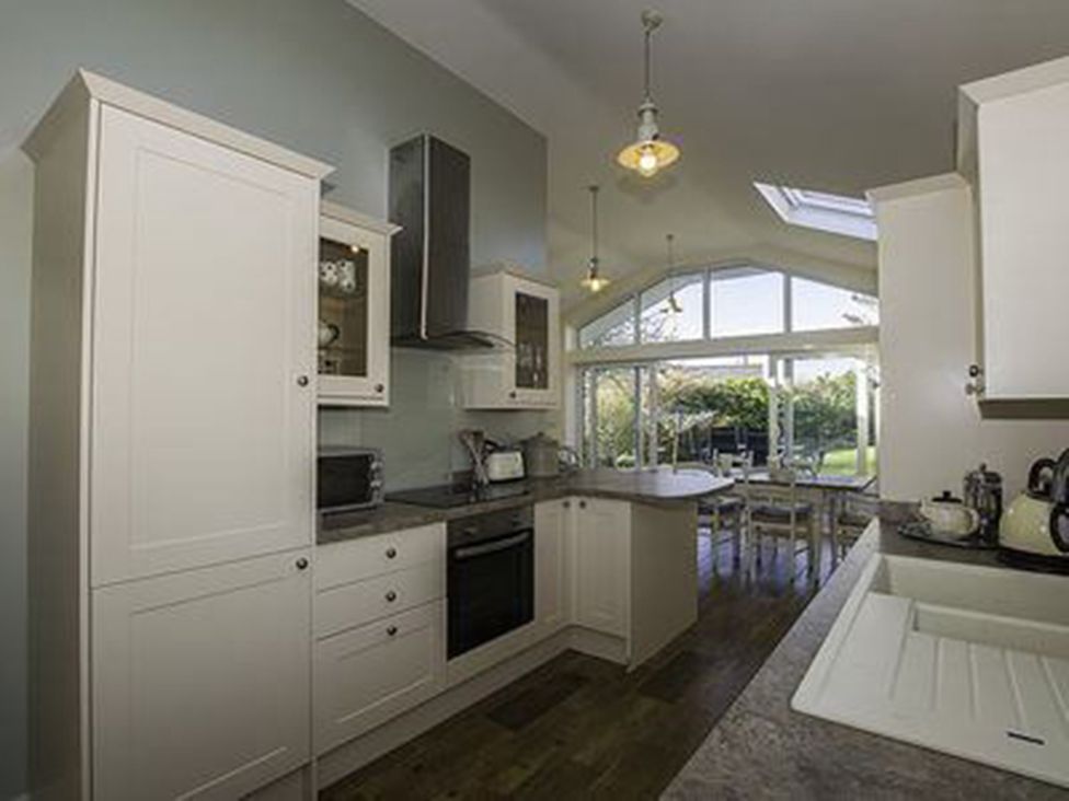 A kitchen with cabinets and appliances at Sea Side Stay 6 Pet Friendly Parking Garden in Rhosneigr