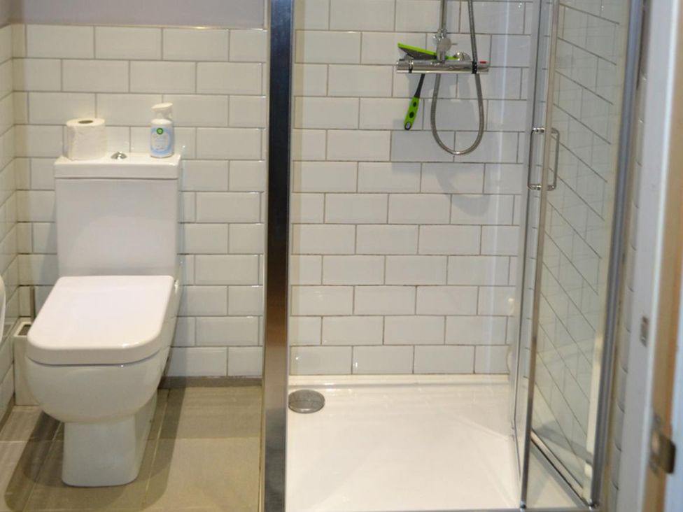A bathroom with a toilet and shower at Sea Side Stay 6 Pet Friendly Parking Garden Rhosneigr