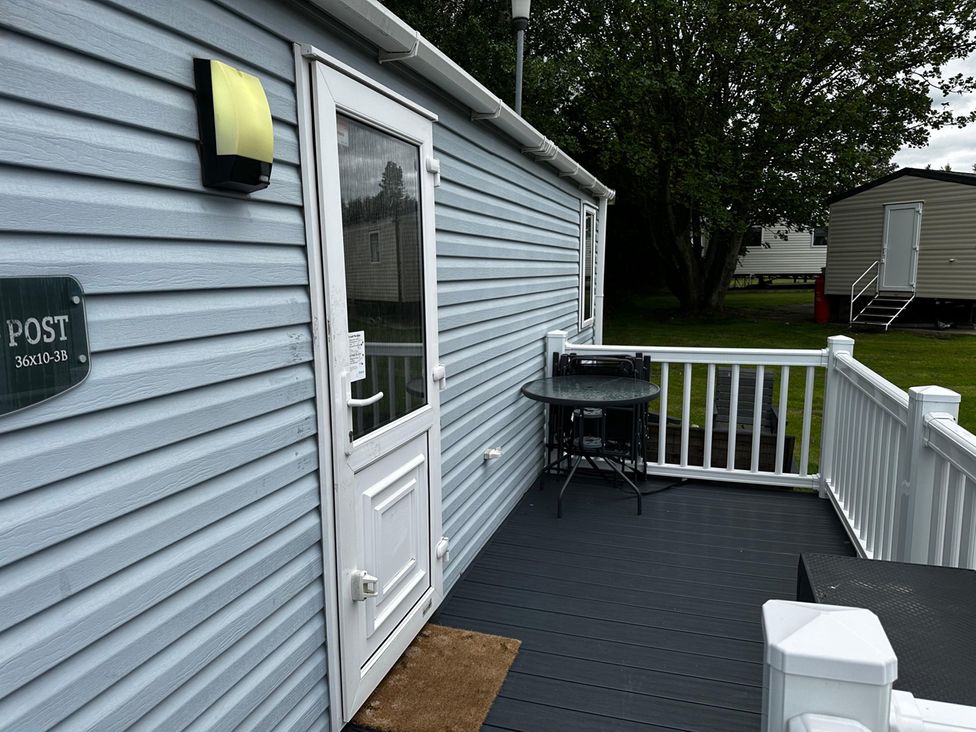 A deck with a table and chairs at the property