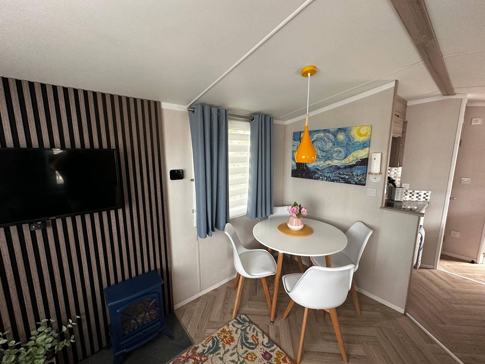 A dining area with a table and chairs at a modern property