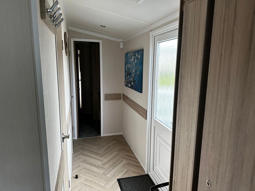 A hallway with a door and a painting at a property