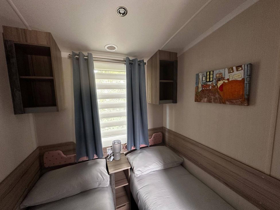 A bedroom with two beds and shelves at 