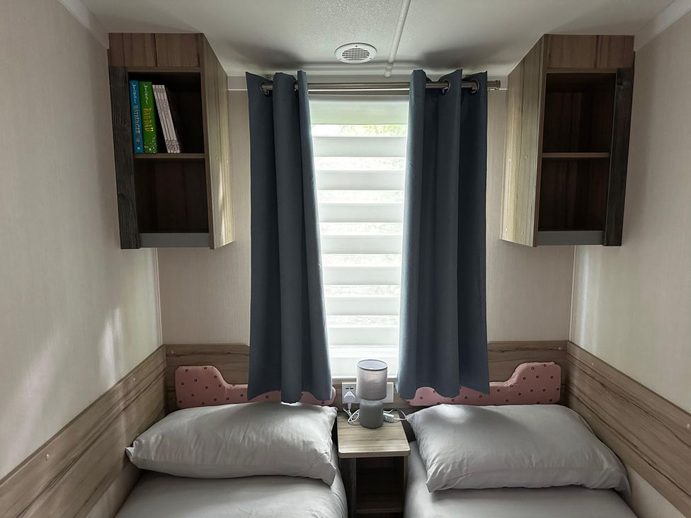 A bedroom with two beds and a shelf at a property
