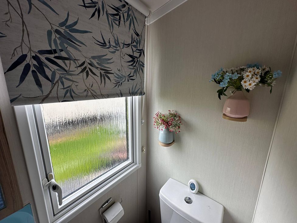 A bathroom with a toilet and a window at the property in the location