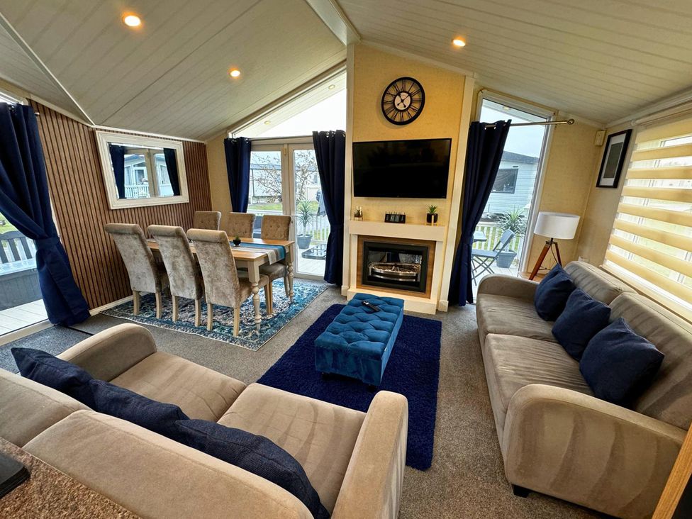 A living room with a sofa and dining table at Sunset 5 Southview Holiday Park Skegness