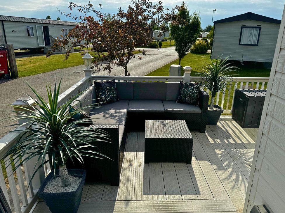 An outdoor seating area with sofa and coffee table at Sunset 5 Southview Holiday Park Skegness