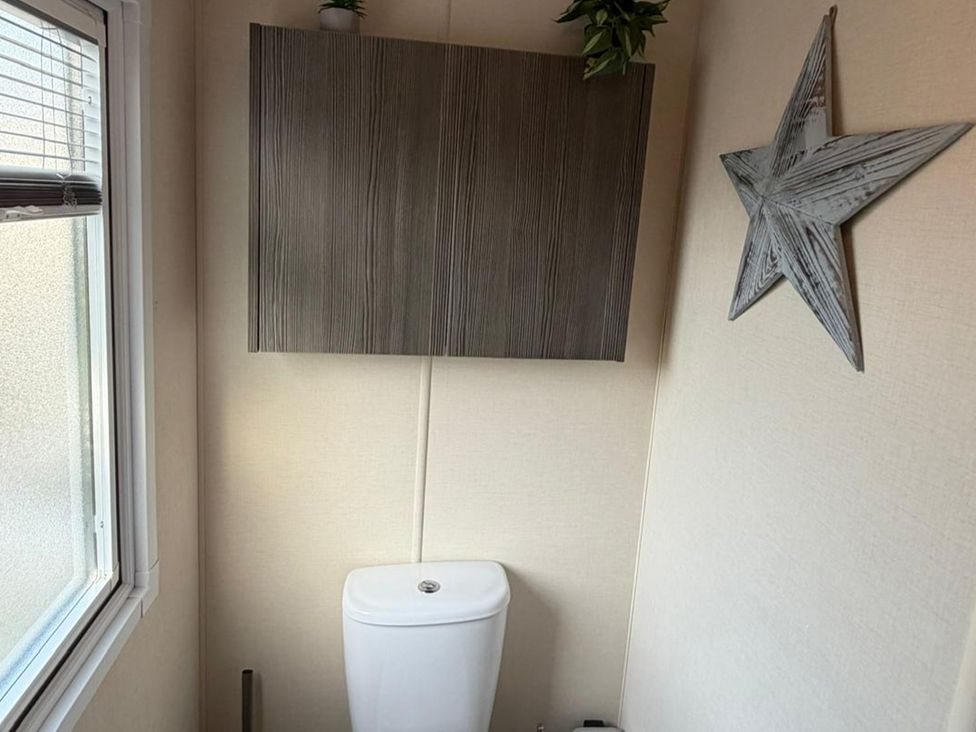 A bathroom with a toilet and a cabinet at 