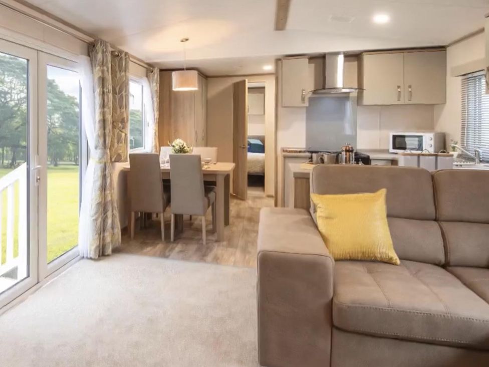 A living room with a sofa, table and chairs at The Old Barn in Manchester