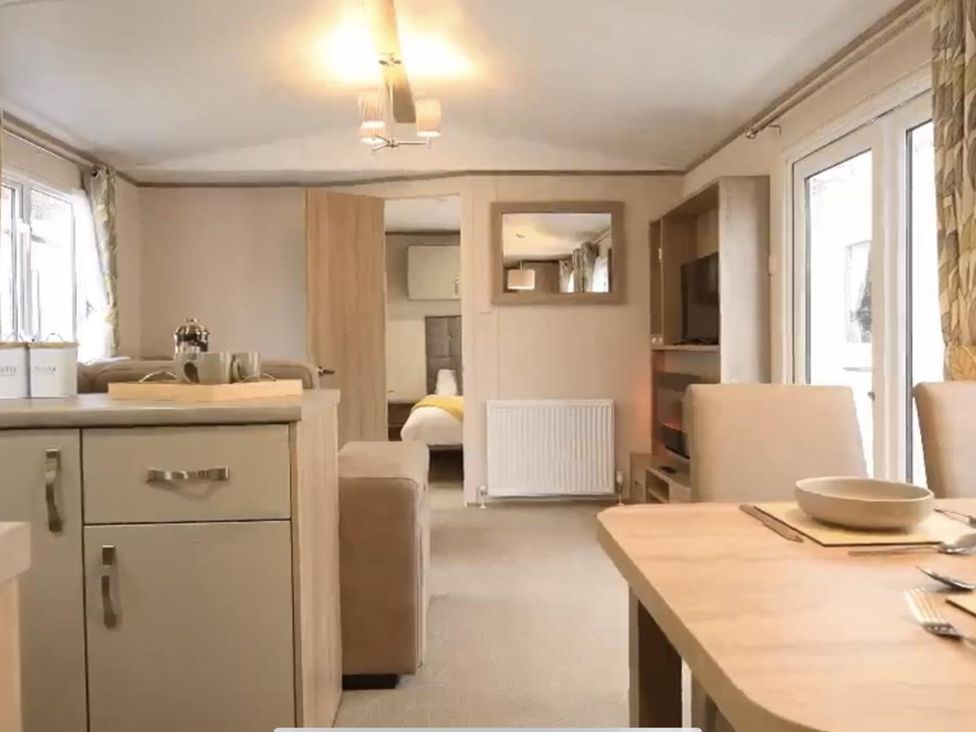 A living room with dining table and television at the property in unspecified location