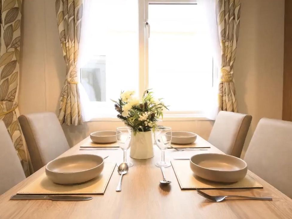 A dining table set with bowls and a flower vase at The Old Barn in Manchester