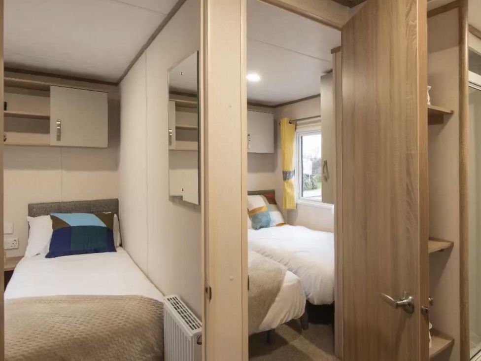 A bedroom with two beds and a mirror at a property