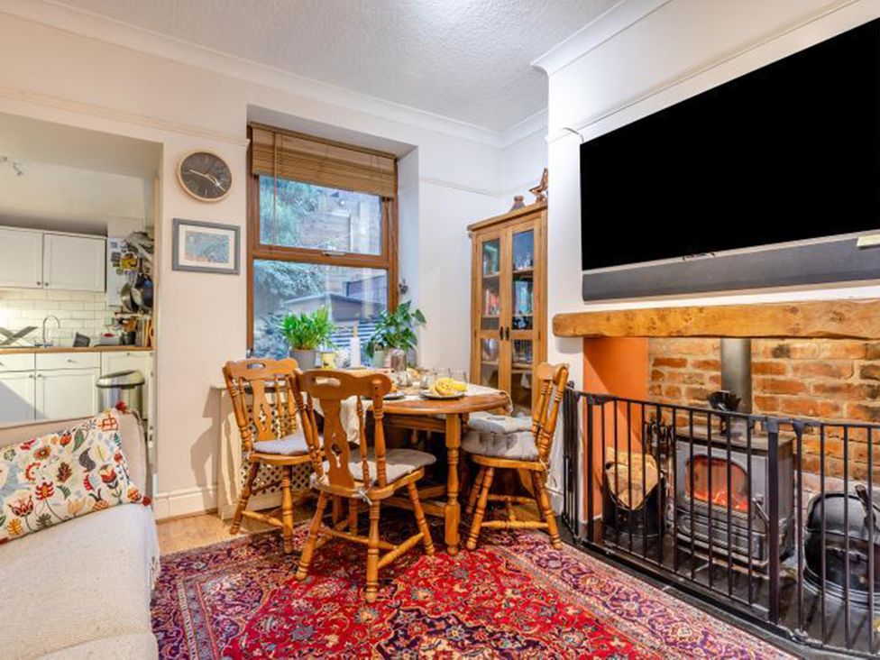 A dining room with a table and chairs next to a fireplace at The Old Barn in Manchester