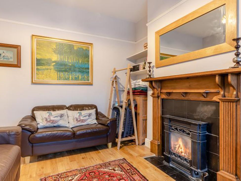 A living room with a fireplace and a painting at the property in location