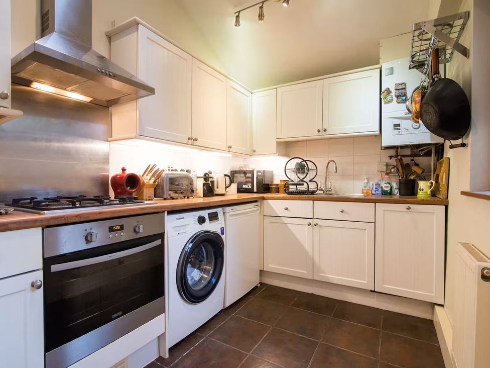 A kitchen with appliances and white cabinets at The Old Barn in Manchester