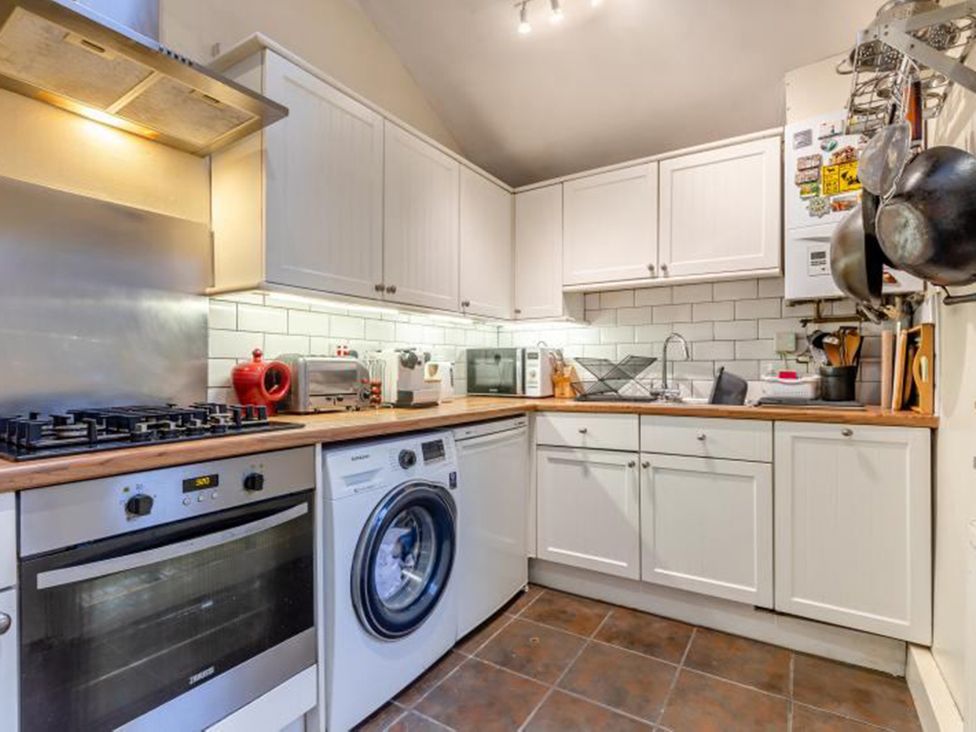 A kitchen equipped with stove, oven, microwave, and washing machine at the property location