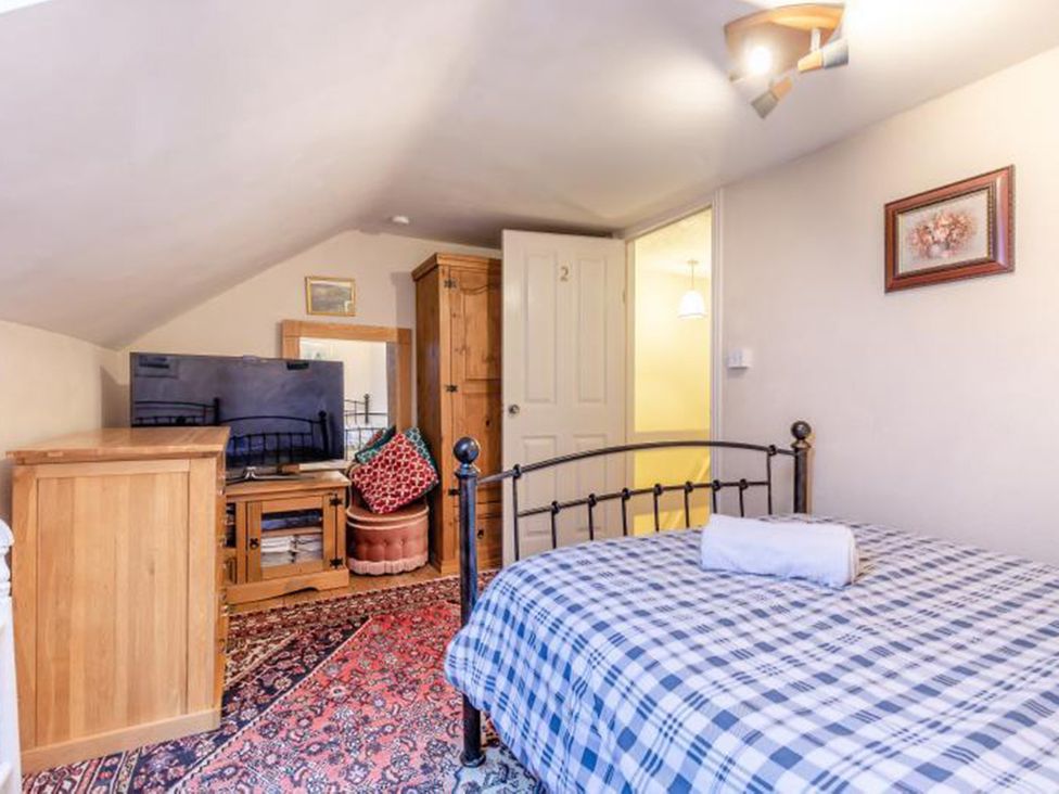 A bedroom with a bed, television, and wardrobe at The Old Barn in Manchester