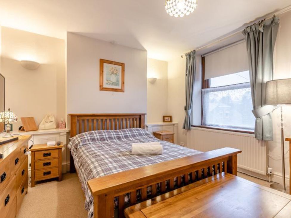 A bedroom with a bed, bedside table, and window at the property