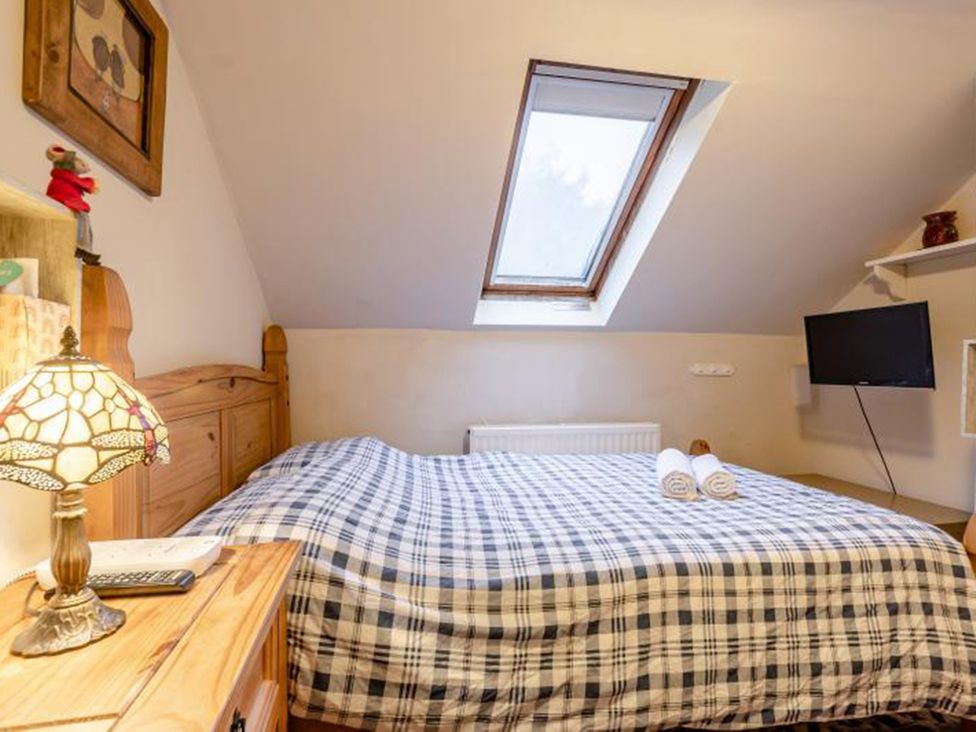 A bedroom with a bed and a television at The Old Barn in Manchester