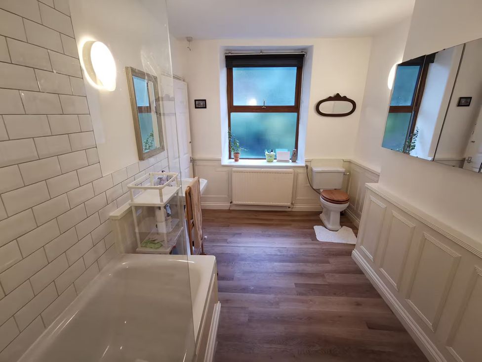 A bathroom with a bathtub, toilet, sink, and window at 