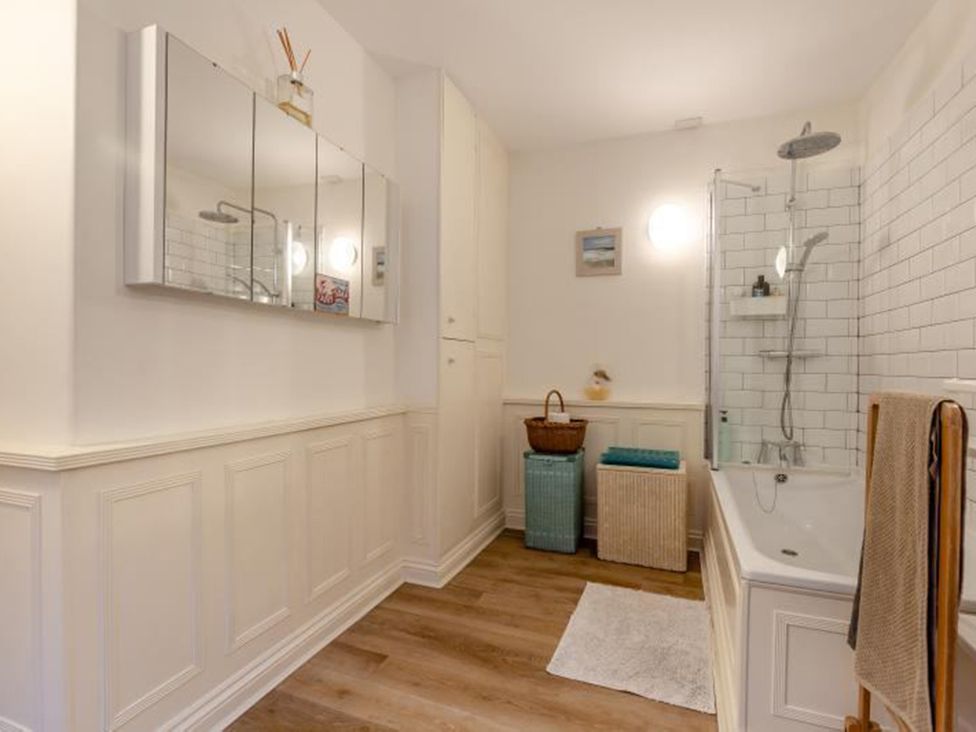 A bathroom with a bathtub and mirror at The Old Barn in Manchester