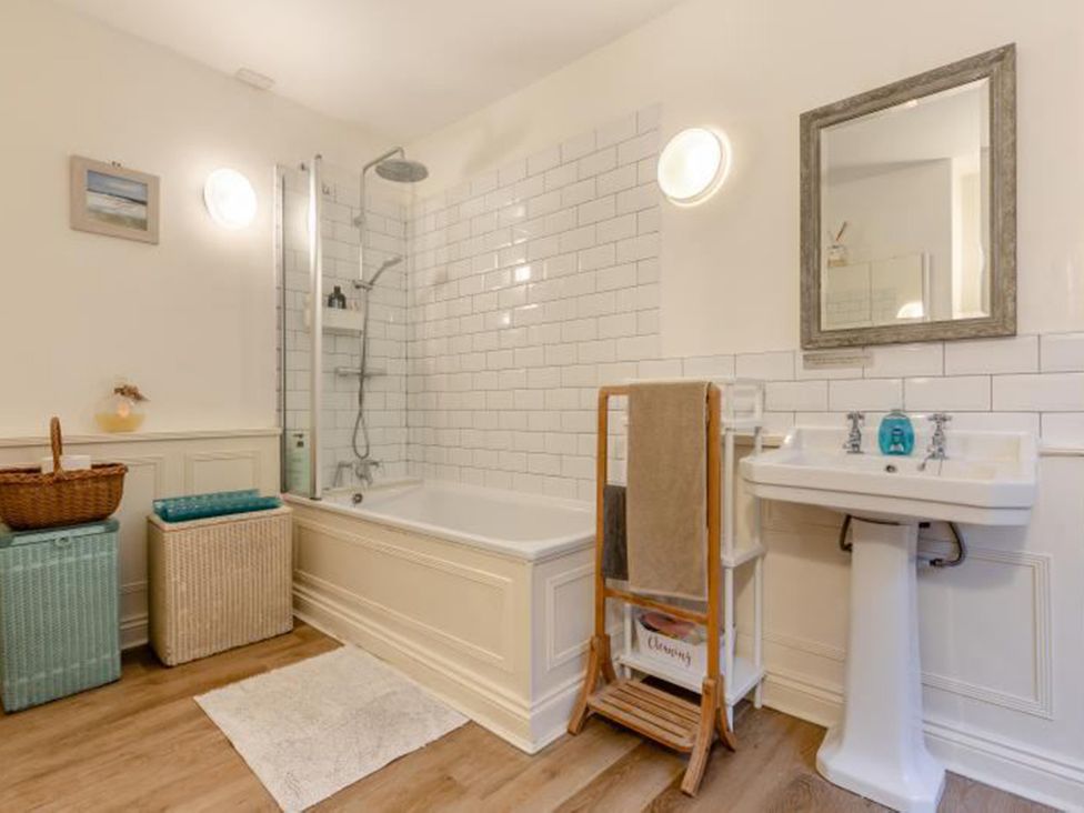 A bathroom with a bathtub, shower, and sink at The Old Barn in Manchester
