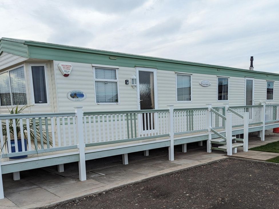 A mobile home with a railing and steps at a holiday park in 
