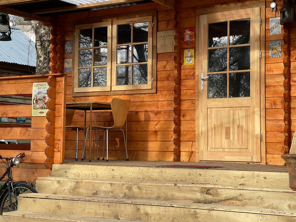 An entrance with stairs, table and chair at a wooden cabin