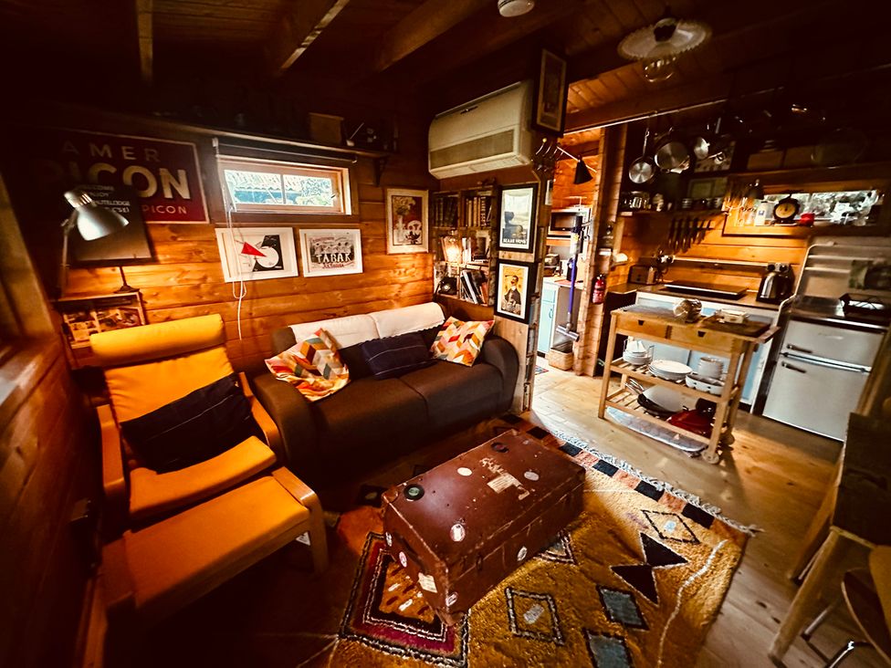 A living room with a sofa and kitchen area at The Old Barn in Manchester