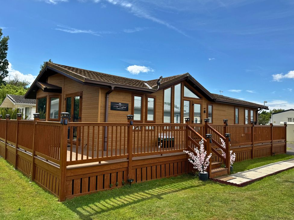 A wooden lodge with decking and stairs at '' in ''