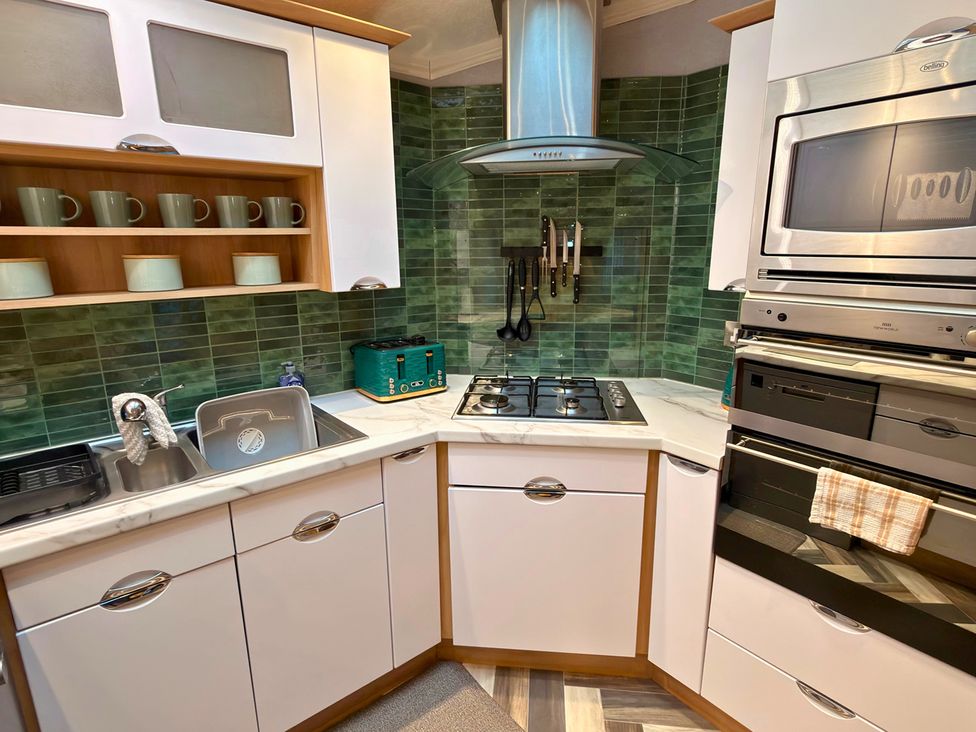 A kitchen with a sink, stove, and cabinets at 