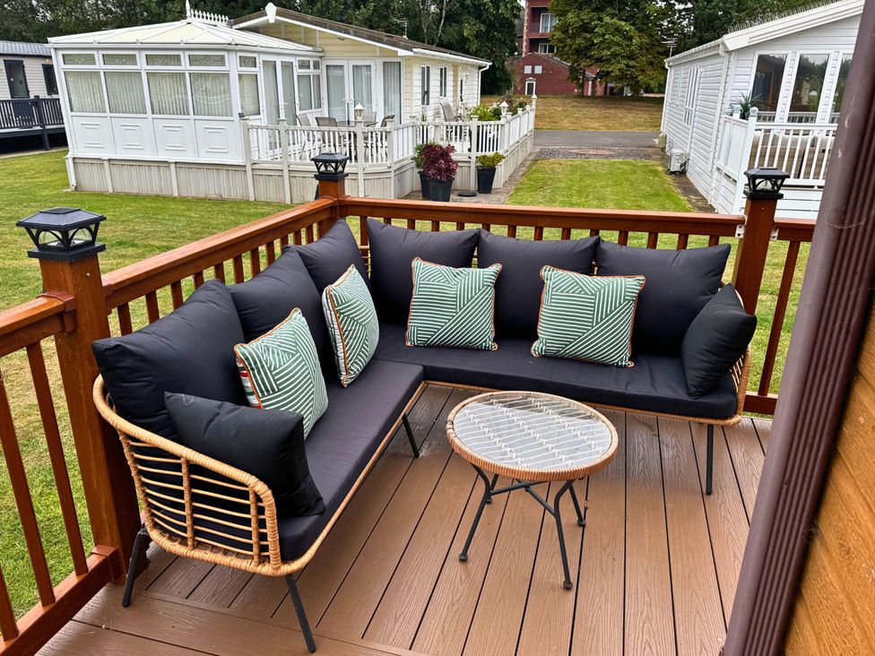A seating area with a couch and table on a deck at a property