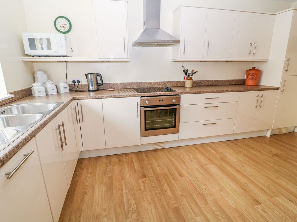 A kitchen with cabinets and appliances at Maple Cottage Tavistock