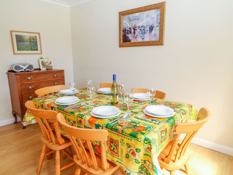 A dining room with a table set for a meal at Maple Cottage in Tavistock