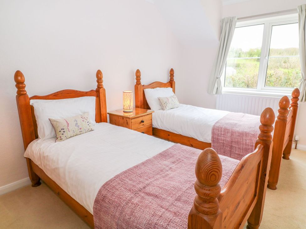 A bedroom with twin beds and a bedside table at Maple Cottage Tavistock