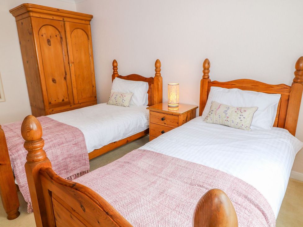 A bedroom with twin beds and a wardrobe at Maple Cottage Tavistock