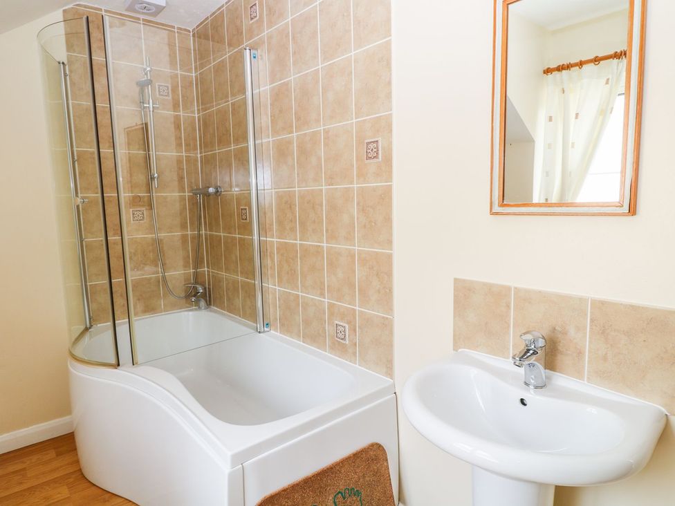 A bathroom with a bathtub and shower at Maple Cottage Tavistock
