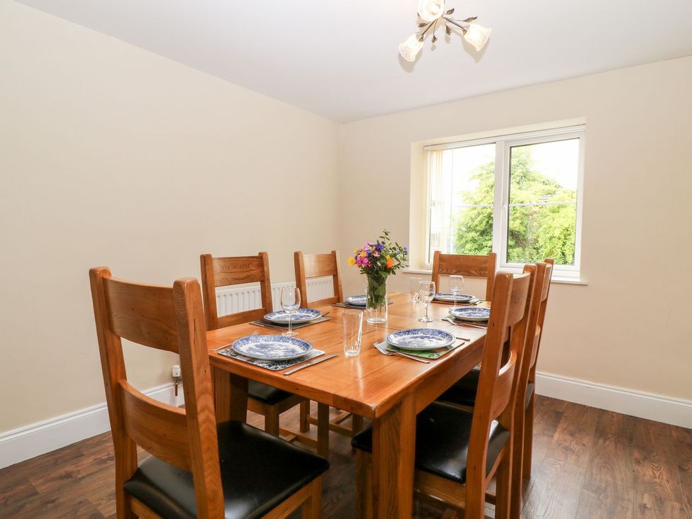 A dining room with a table and chairs at Honeysuckle in Tavistock