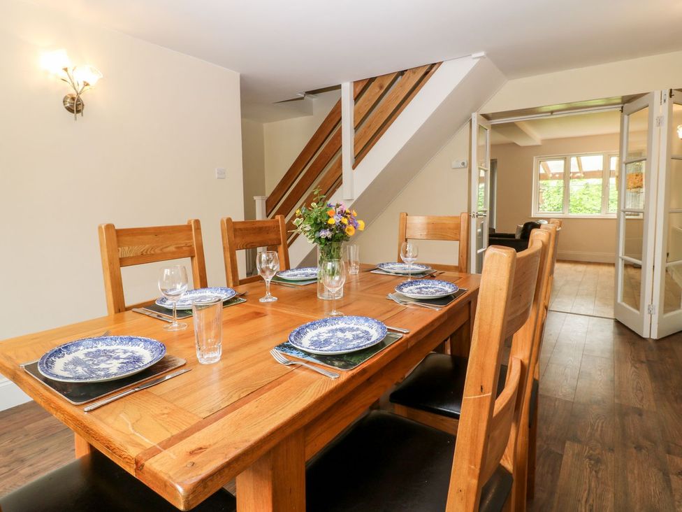 A dining room with table and chairs at Honeysuckle in Tavistock