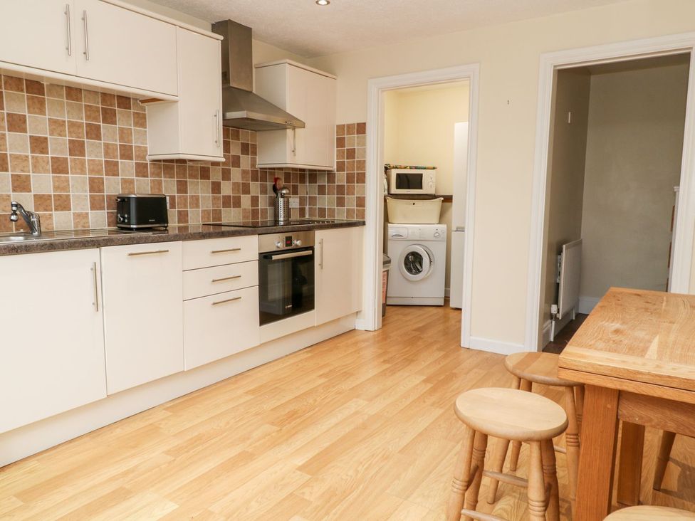 A kitchen with cabinets and appliances at Honeysuckle in Tavistock