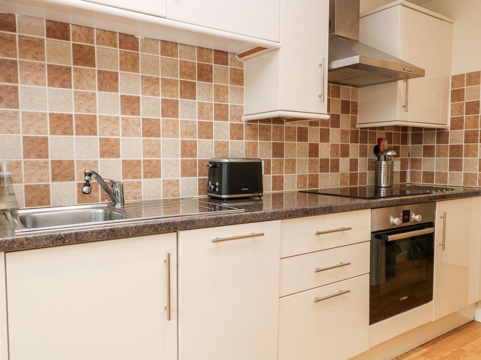 A kitchen with appliances and cabinetry at Honeysuckle Tavistock