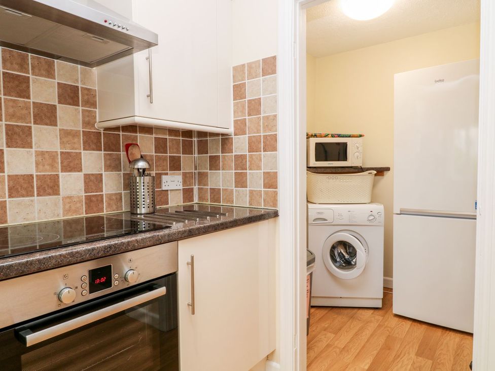 A kitchen featuring appliances like a fridge and washing machine at Honeysuckle in Tavistock