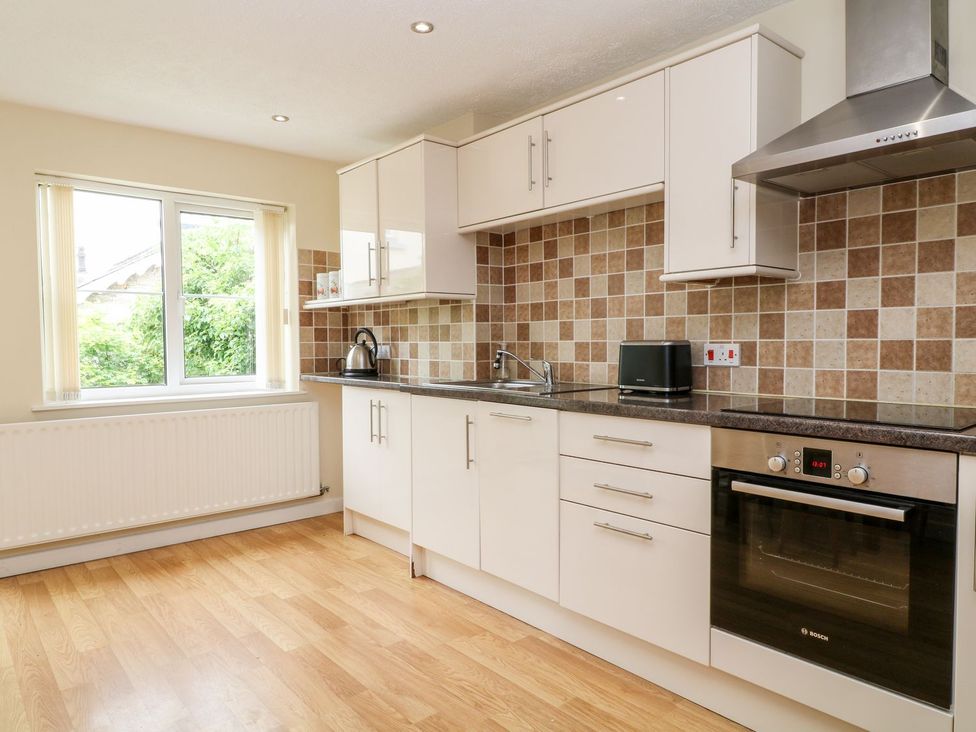 A kitchen with cupboards and appliances at Honeysuckle in Tavistock