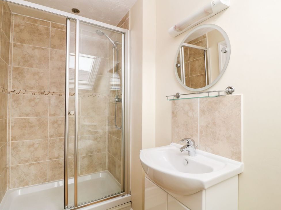 A bathroom with shower and sink at Honeysuckle in Tavistock